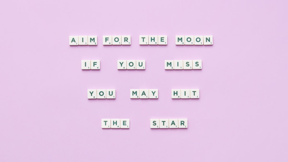 Inspirational message using Scrabble tiles on a pastel background.